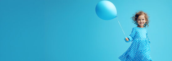Banner of a little girl running with an inflatable ball isolated on a blue background. Copy space